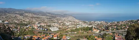 Funchal spreads across hills toward the harbour, showing the slopes above the waterfront walks.